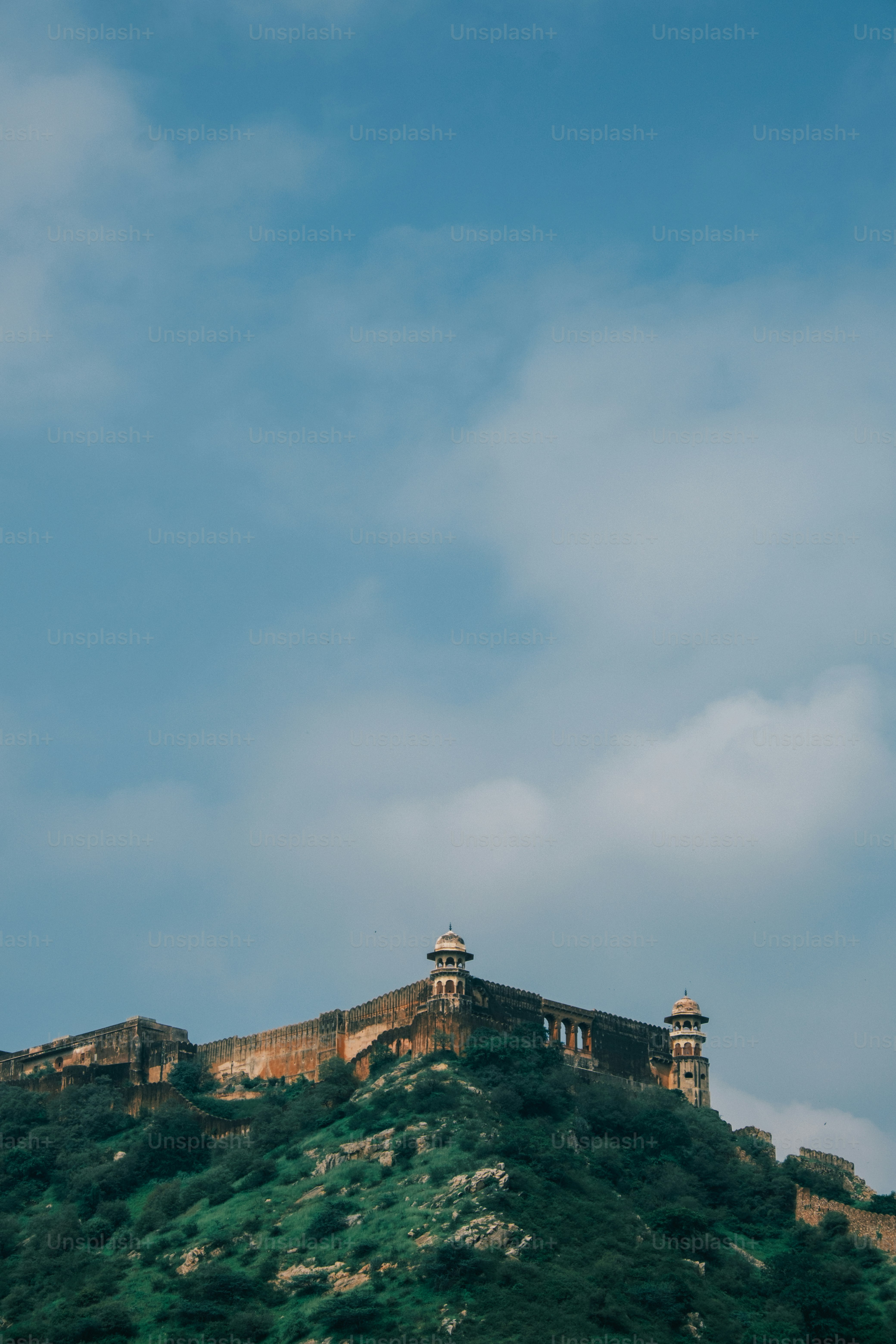 a large building on top of a green hill