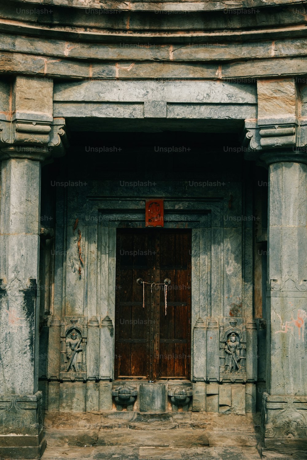 an old building with a red sign on the door