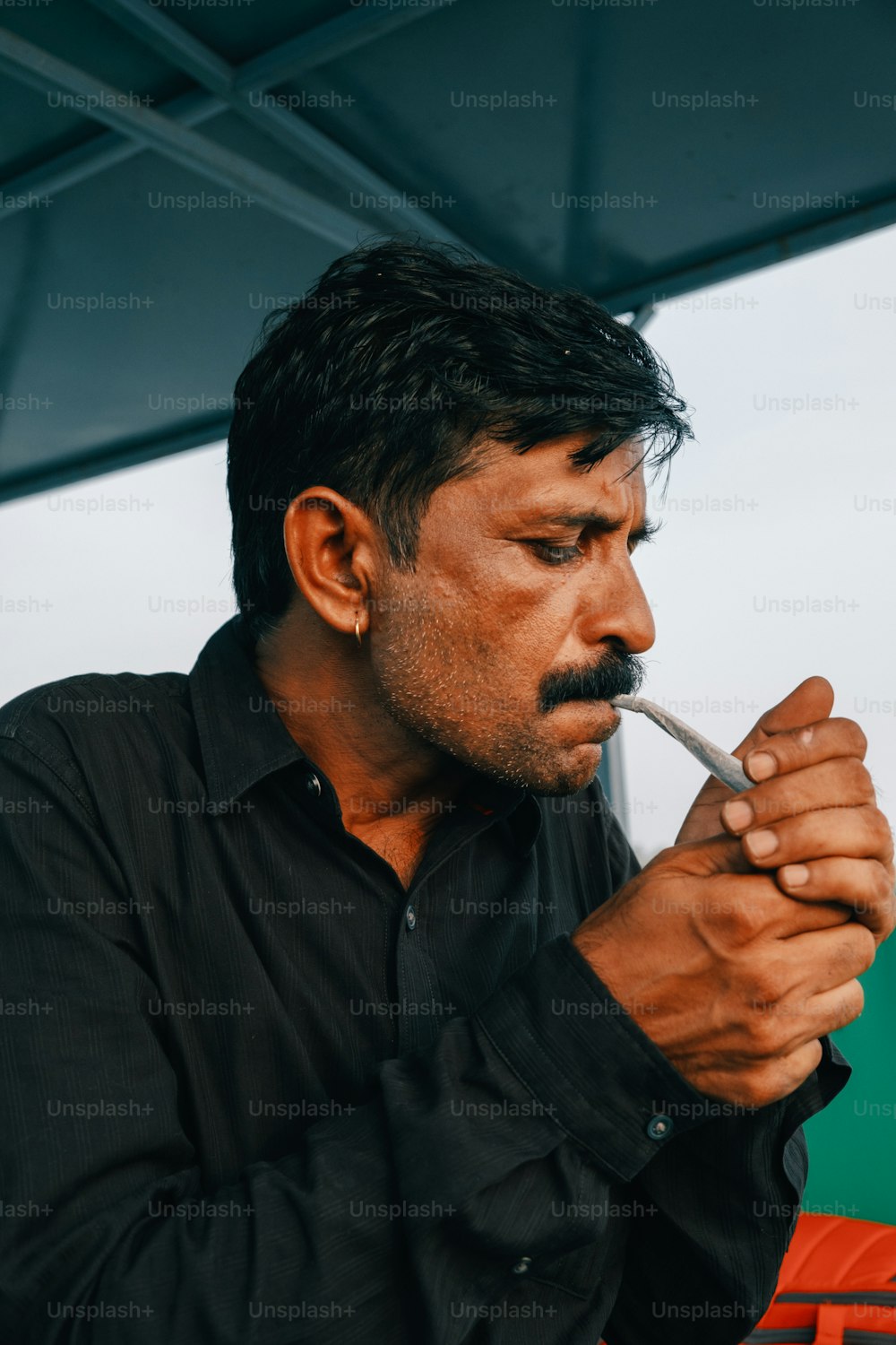 a man holding a cigarette in his mouth