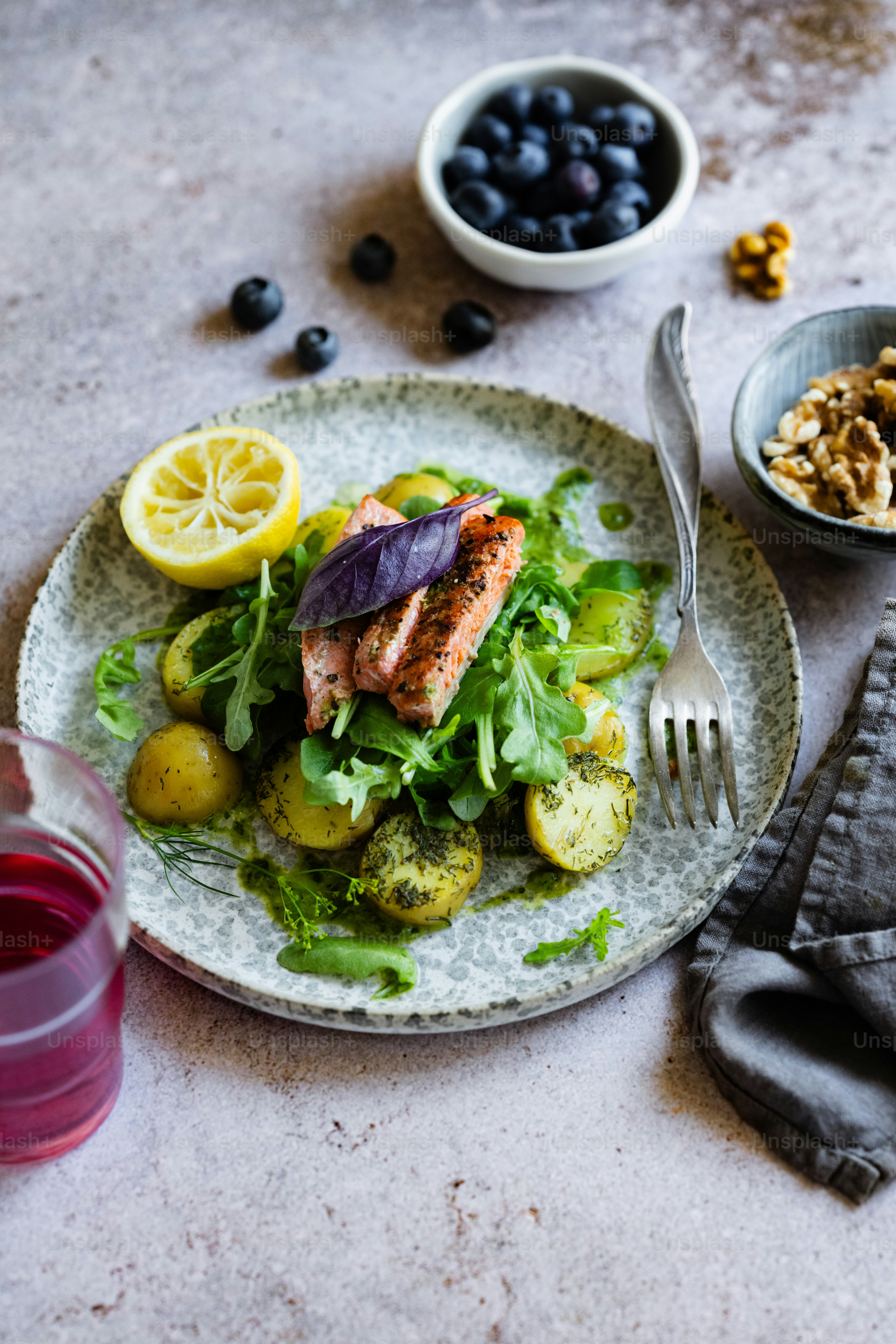 Foto zum Thema Ein weißer Teller mit Salat neben einer Schüssel Obst ...