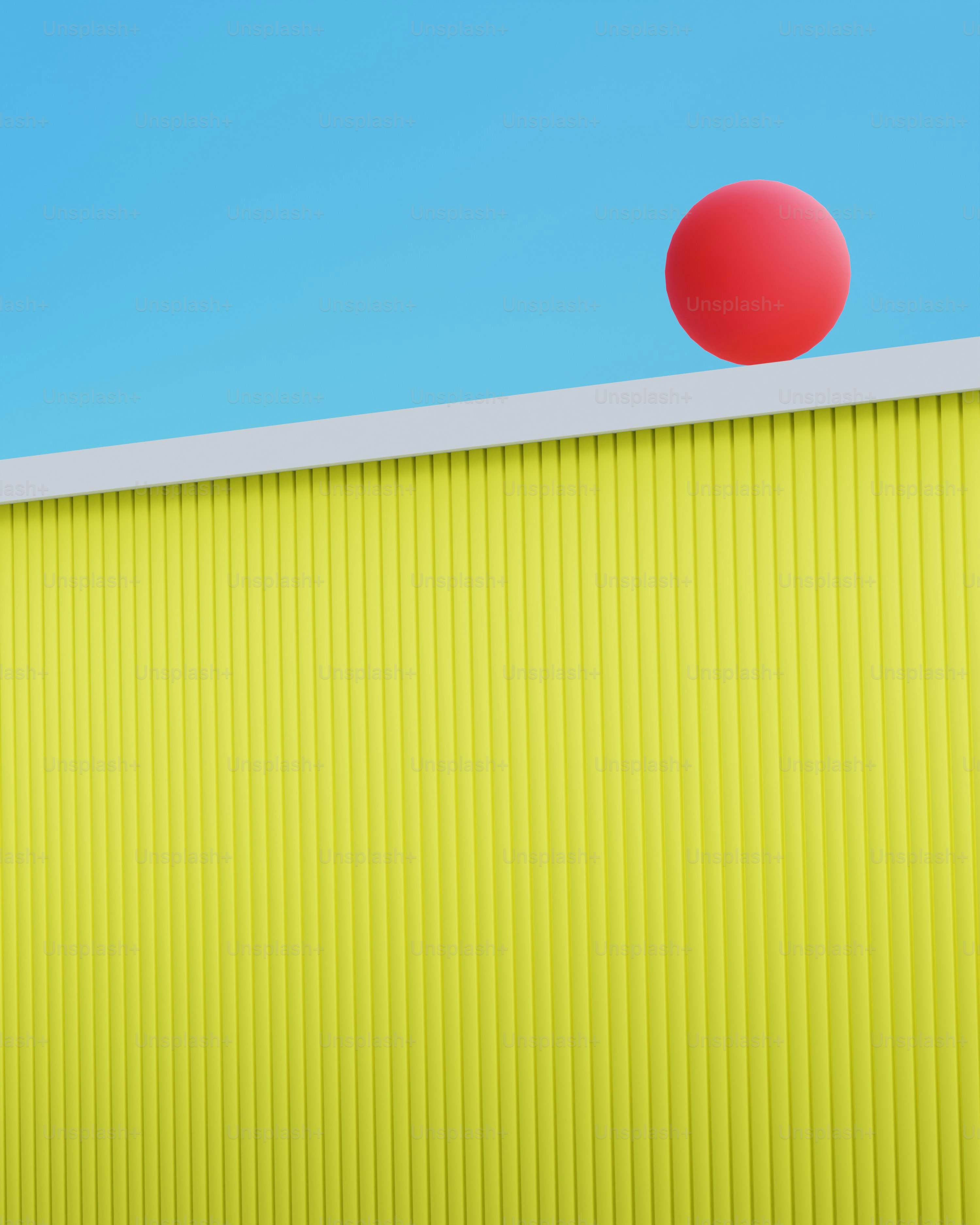 a red ball sitting on top of a yellow wall