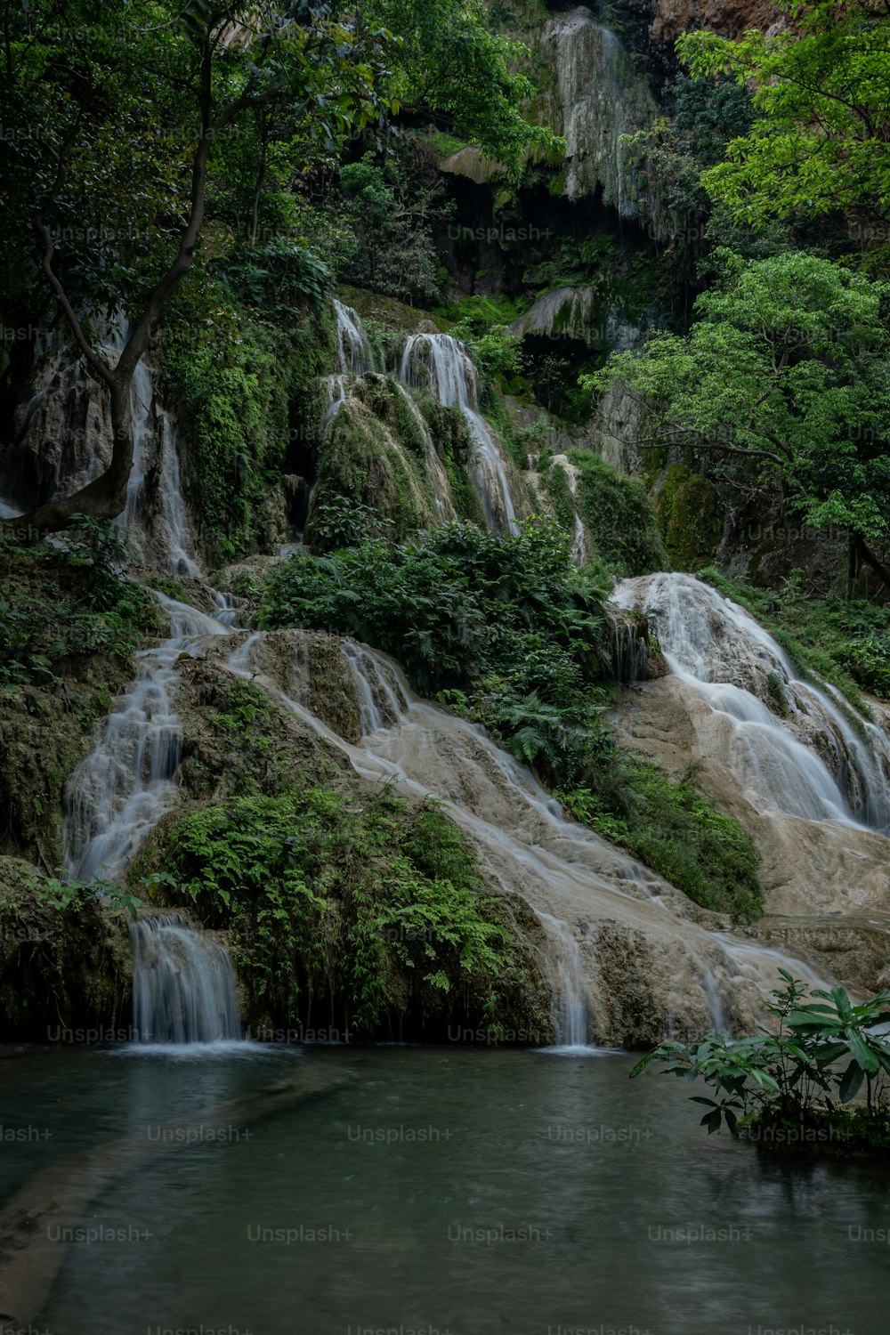 a large waterfall in the middle of a forest