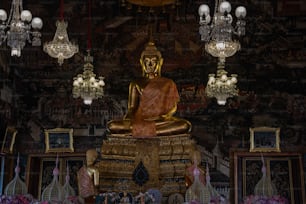 Uma estátua dourada de Buda sentada em cima de uma mesa de madeira
