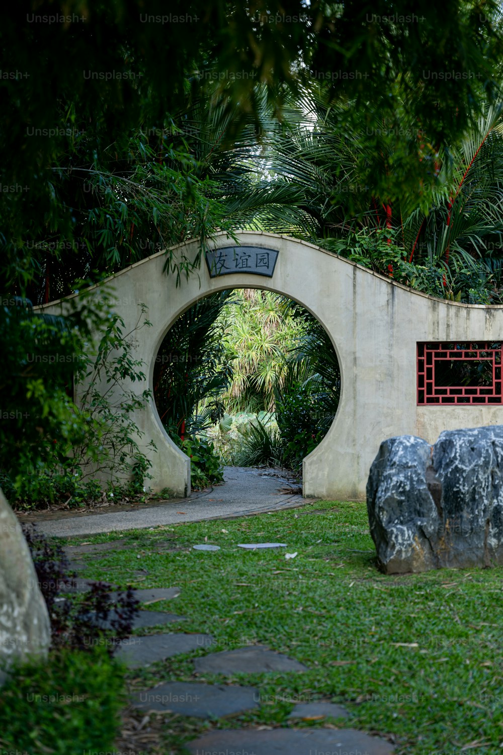 a stone bench sitting in the middle of a lush green park