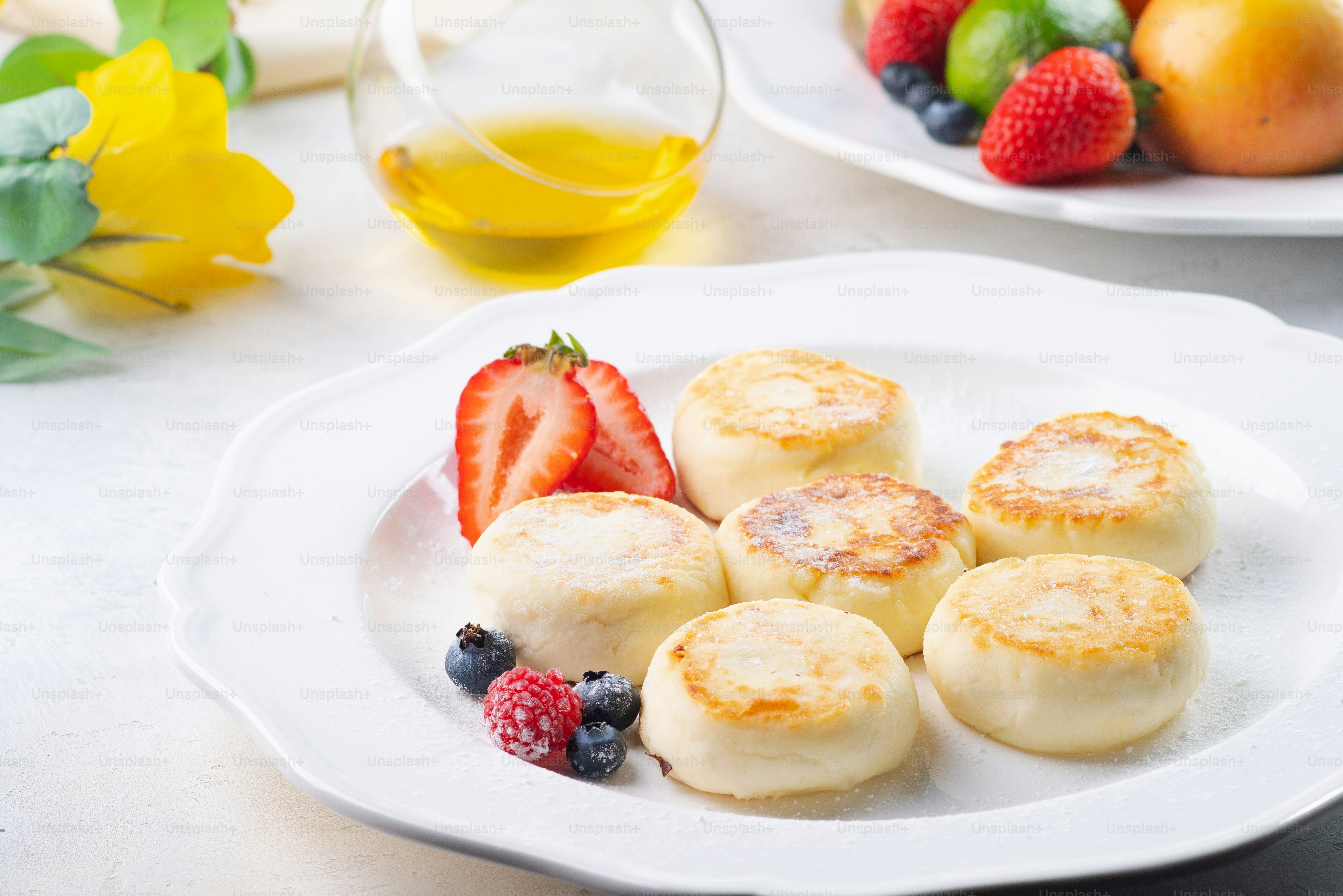 a white plate topped with dessert next to a bowl of fruit