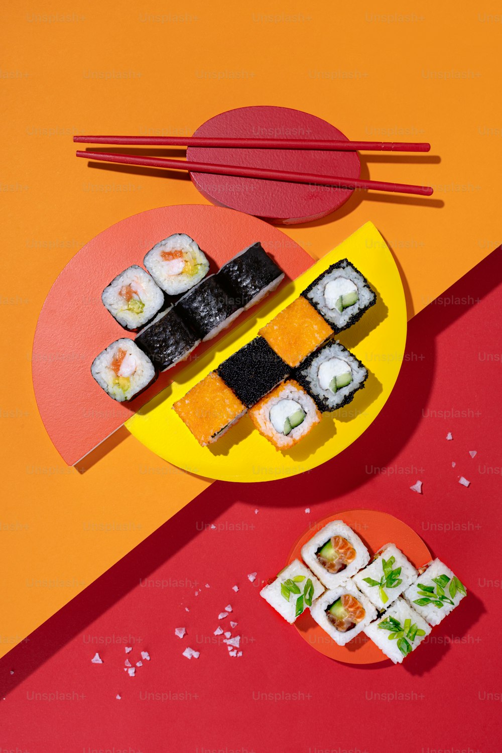 a plate of sushi next to a plate of chopsticks