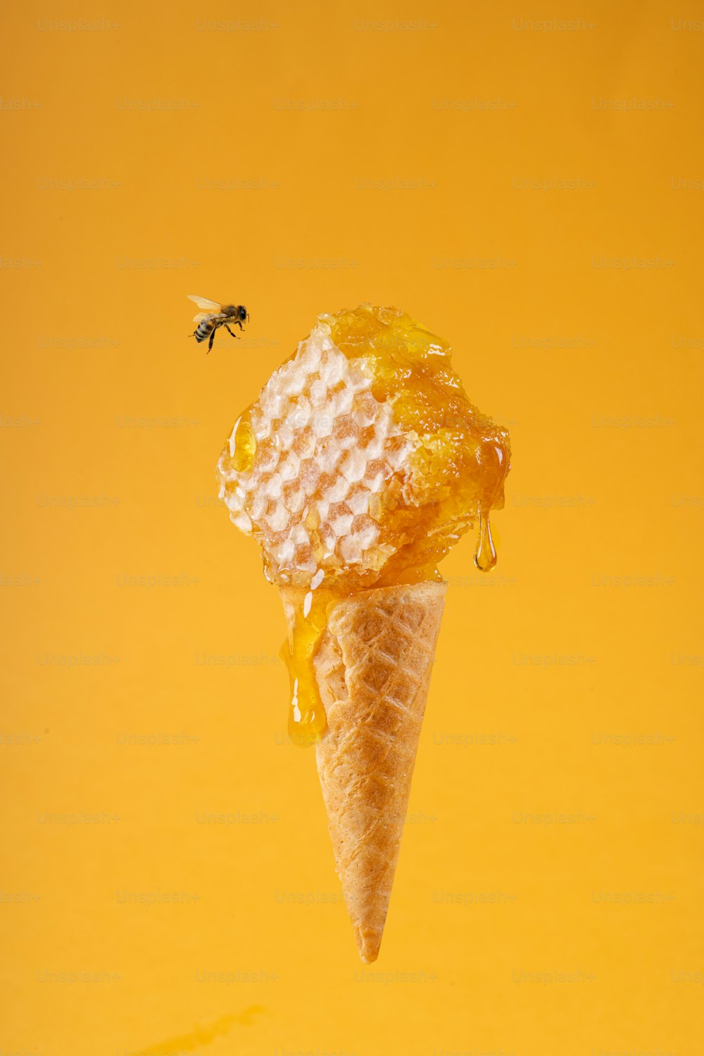an ice cream cone with honeycombs and a bee