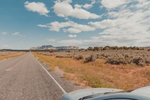 a car driving down a road in the middle of the desert