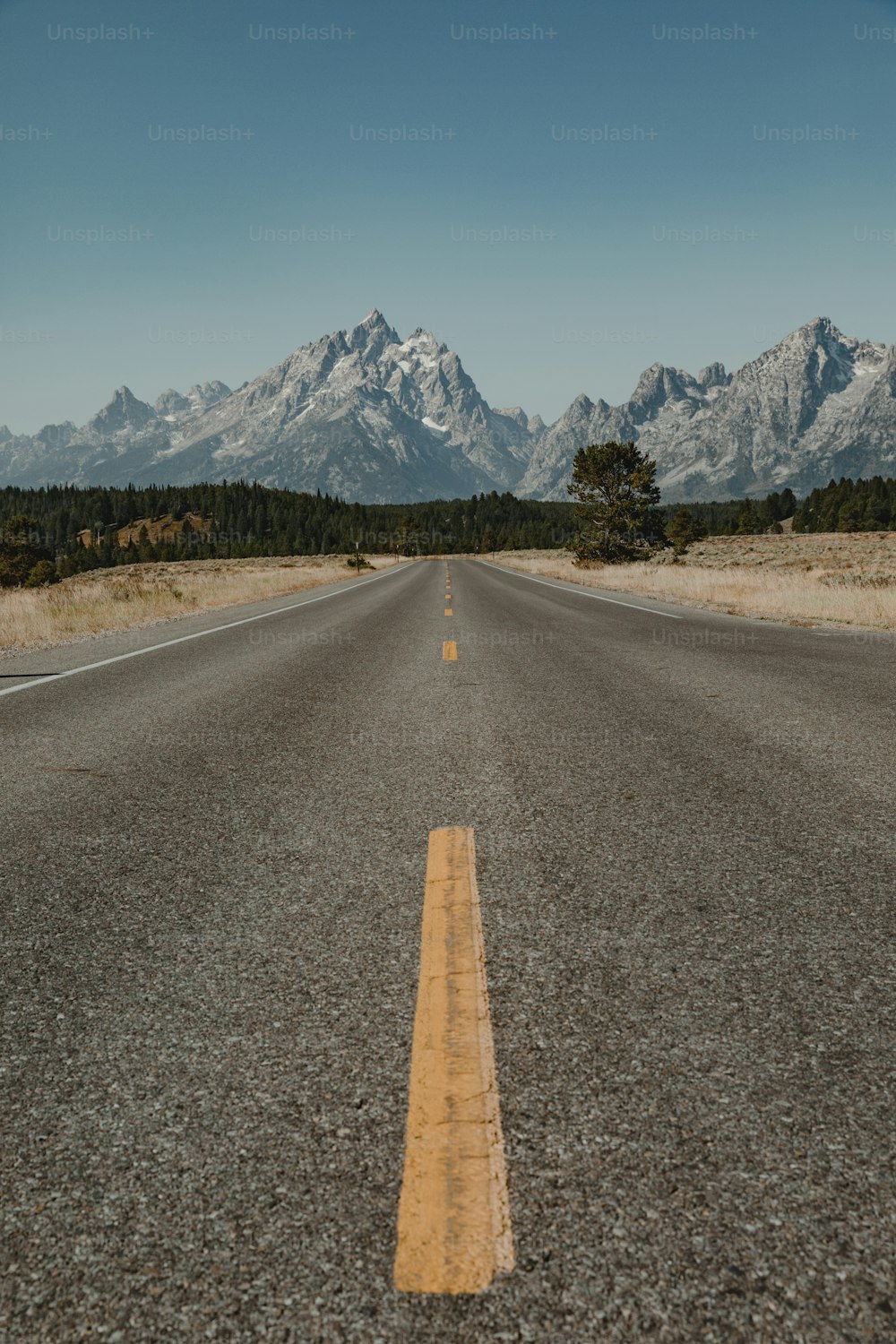 uma estrada vazia com montanhas ao fundo