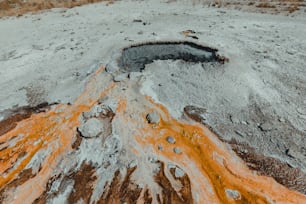 a large hole in the ground with orange and white paint on it