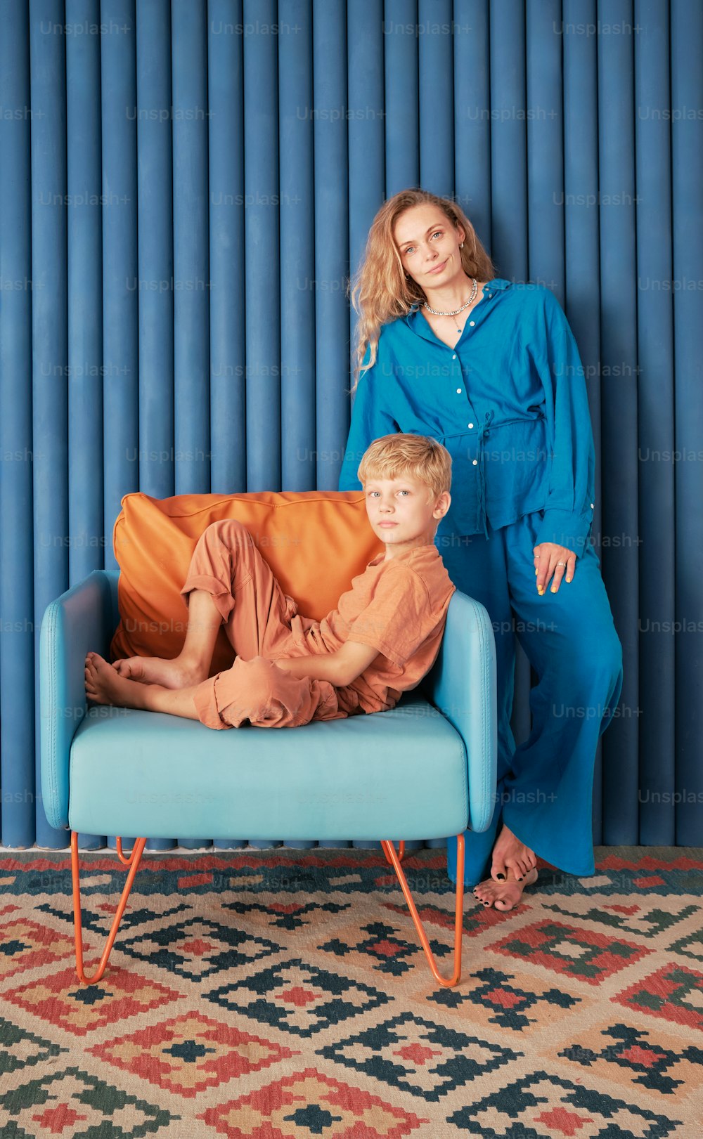 a woman and a boy sitting on a blue couch