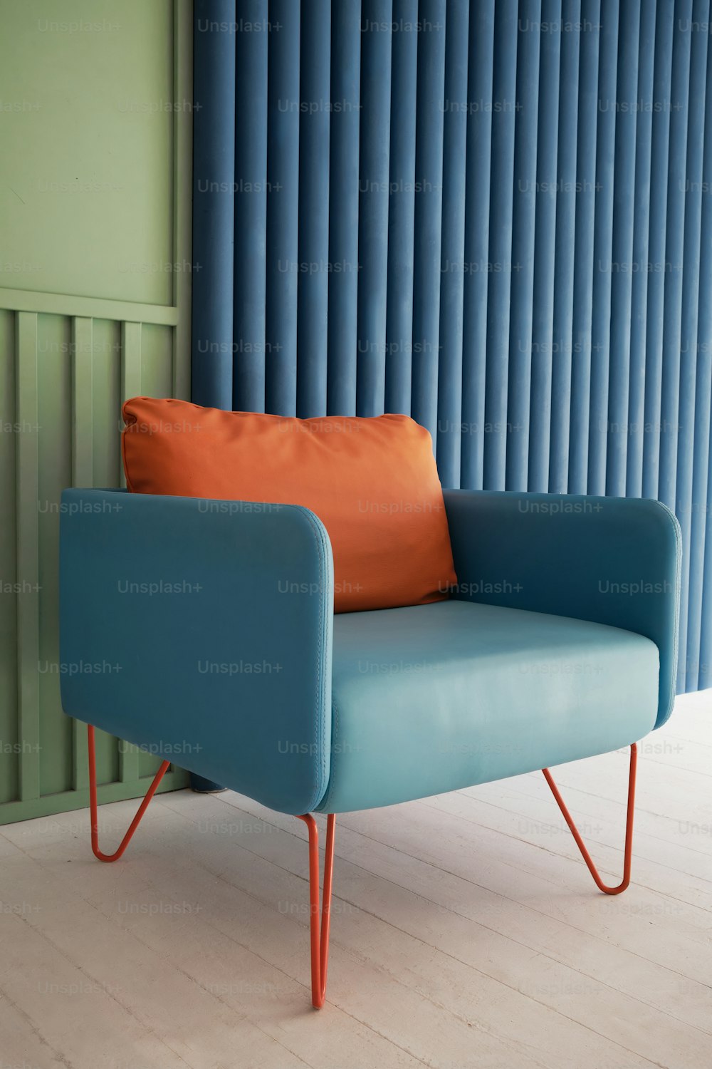 a blue chair with an orange pillow on top of it