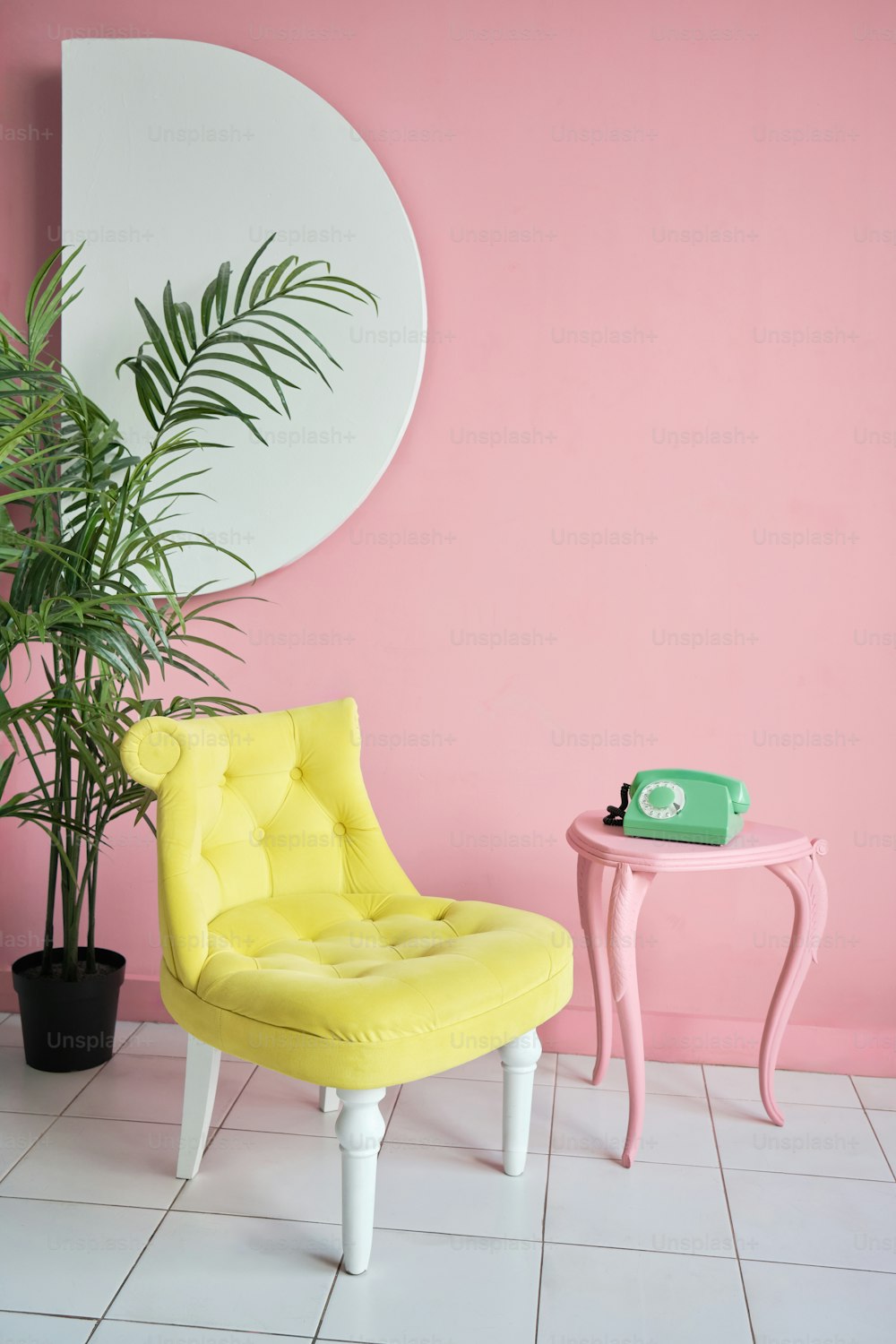 uma cadeira amarela sentada ao lado de uma mesa rosa