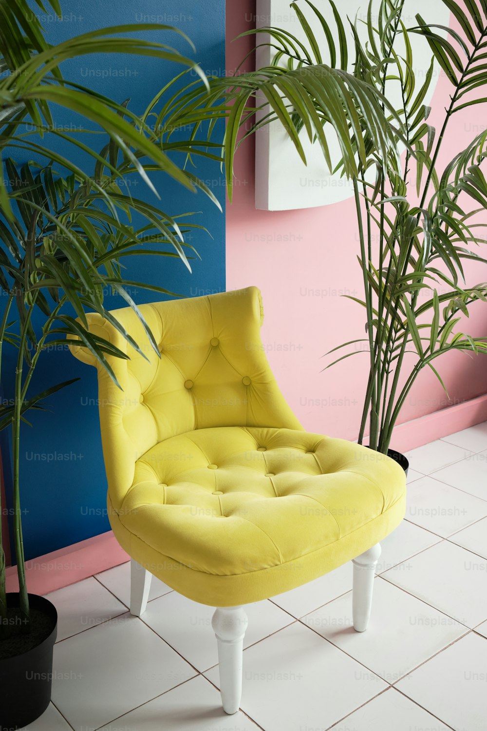 a yellow chair sitting next to a potted plant