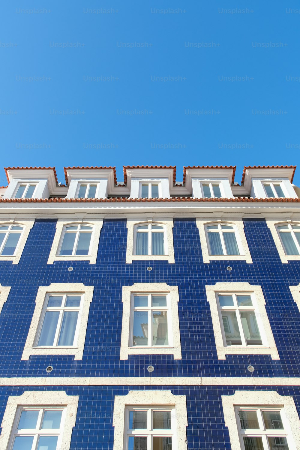 Ein blaues Gebäude mit weißen Fenstern und einer Uhr