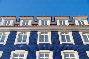 a blue and white building with windows and tiled roof