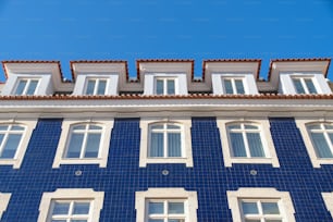 창문과 기와 지붕이 있는 파란색과 흰색 건물