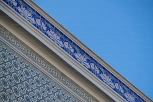 a close up of a blue and white wall with a blue sky in the background