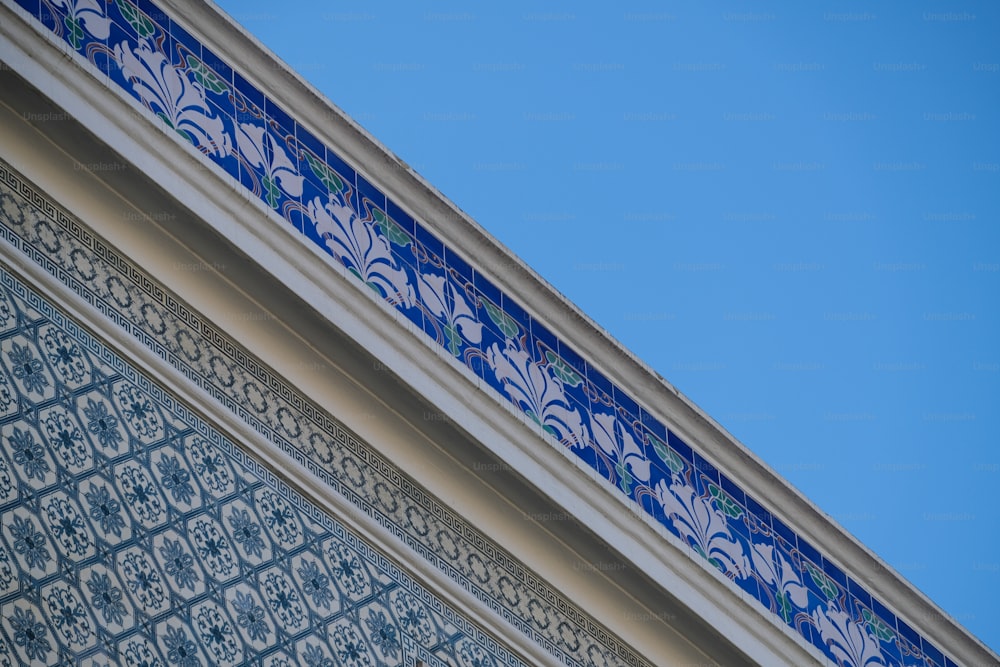 um close up de uma parede azul e branca com um céu azul no fundo