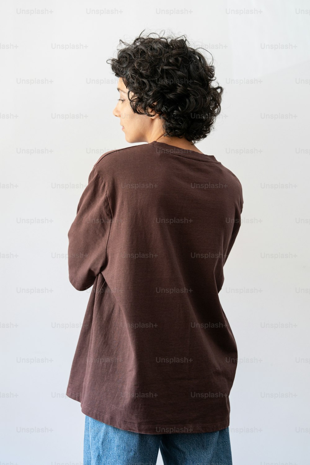 a woman standing in front of a white wall