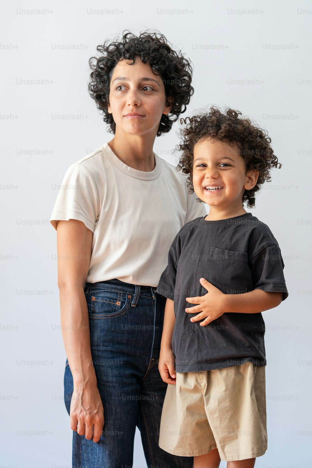 a woman standing next to a little boy