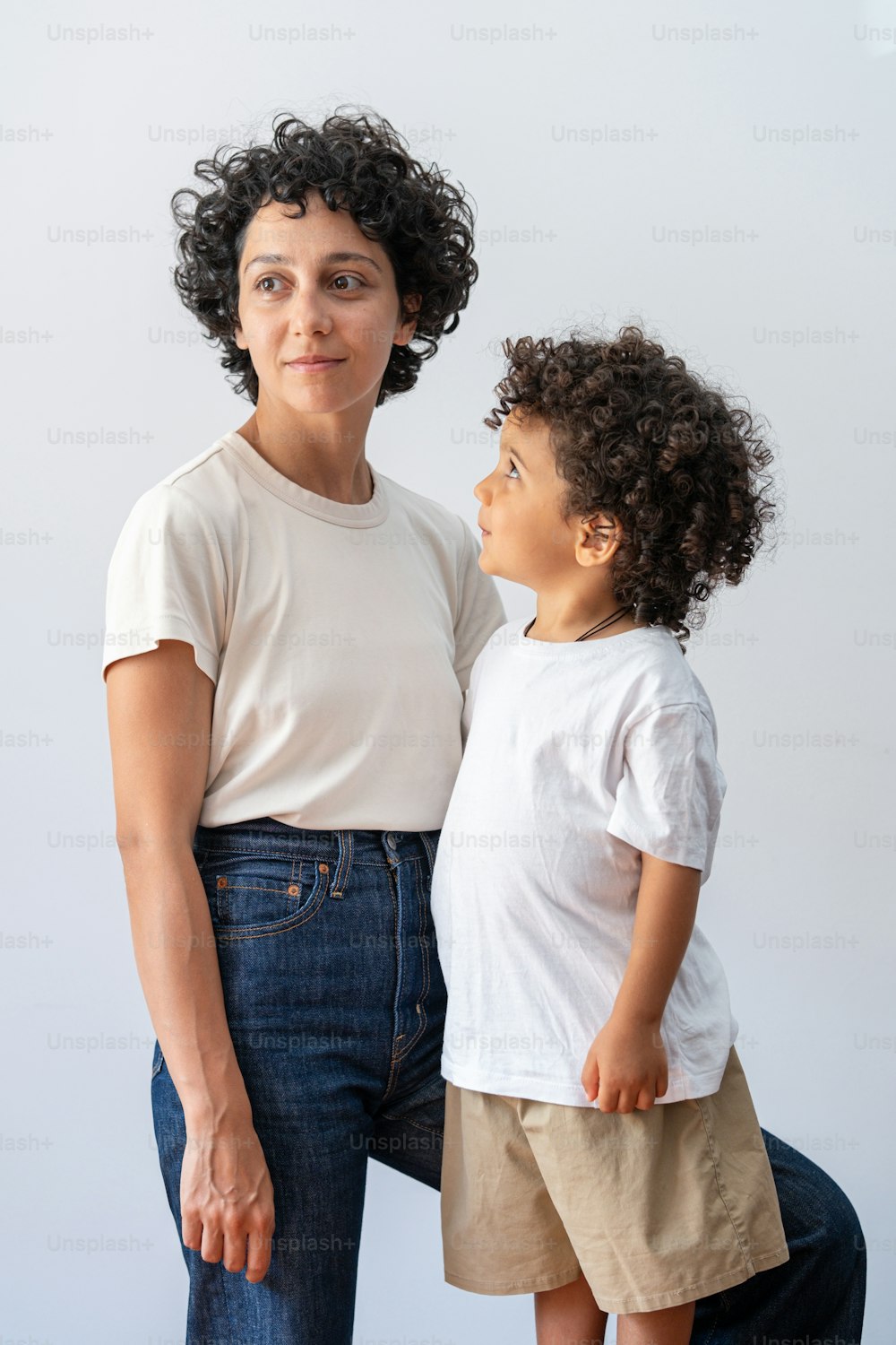 a woman standing next to a little boy