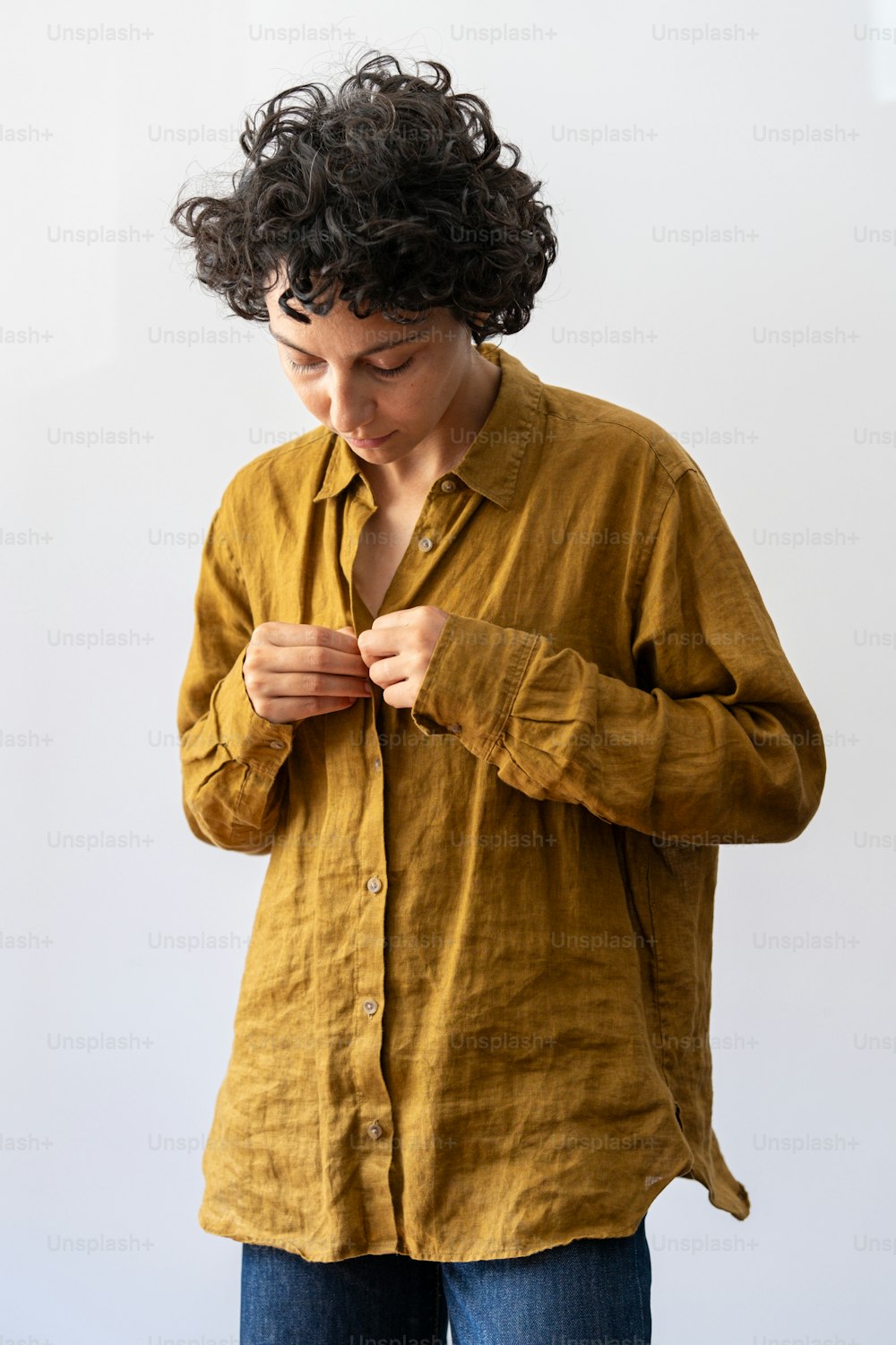 a woman in a yellow shirt is looking down