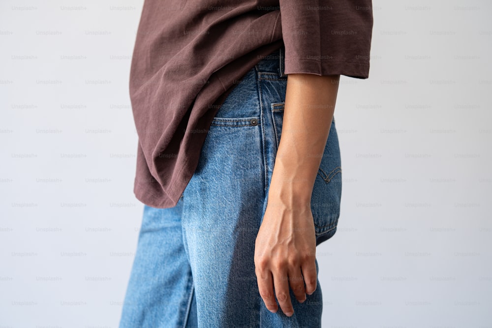 a person wearing a brown shirt and jeans