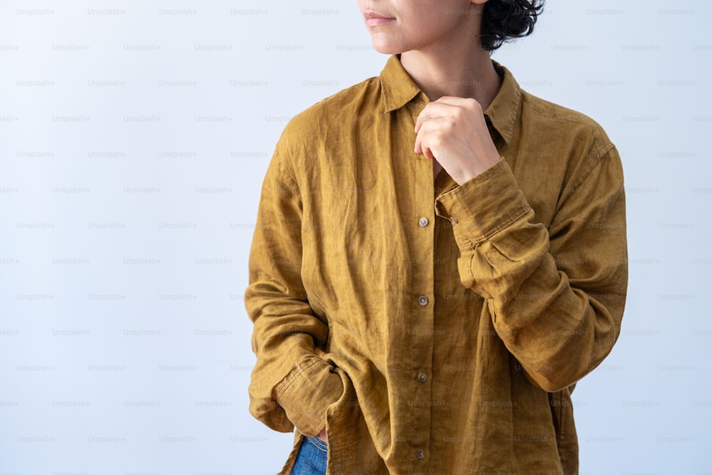 a woman in a brown shirt is holding her hand on her shoulder