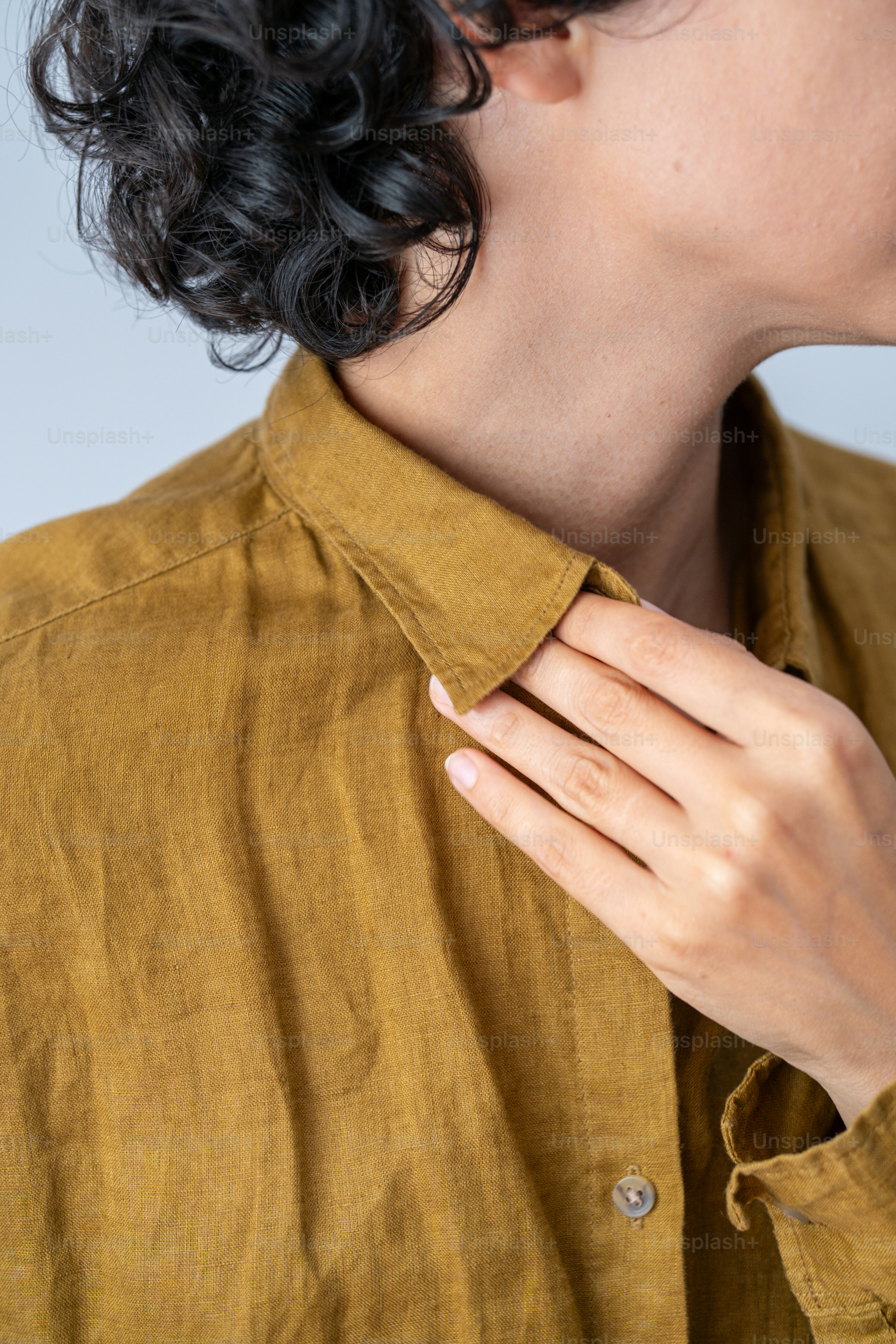 a woman wearing a gold shirt and a diamond ring