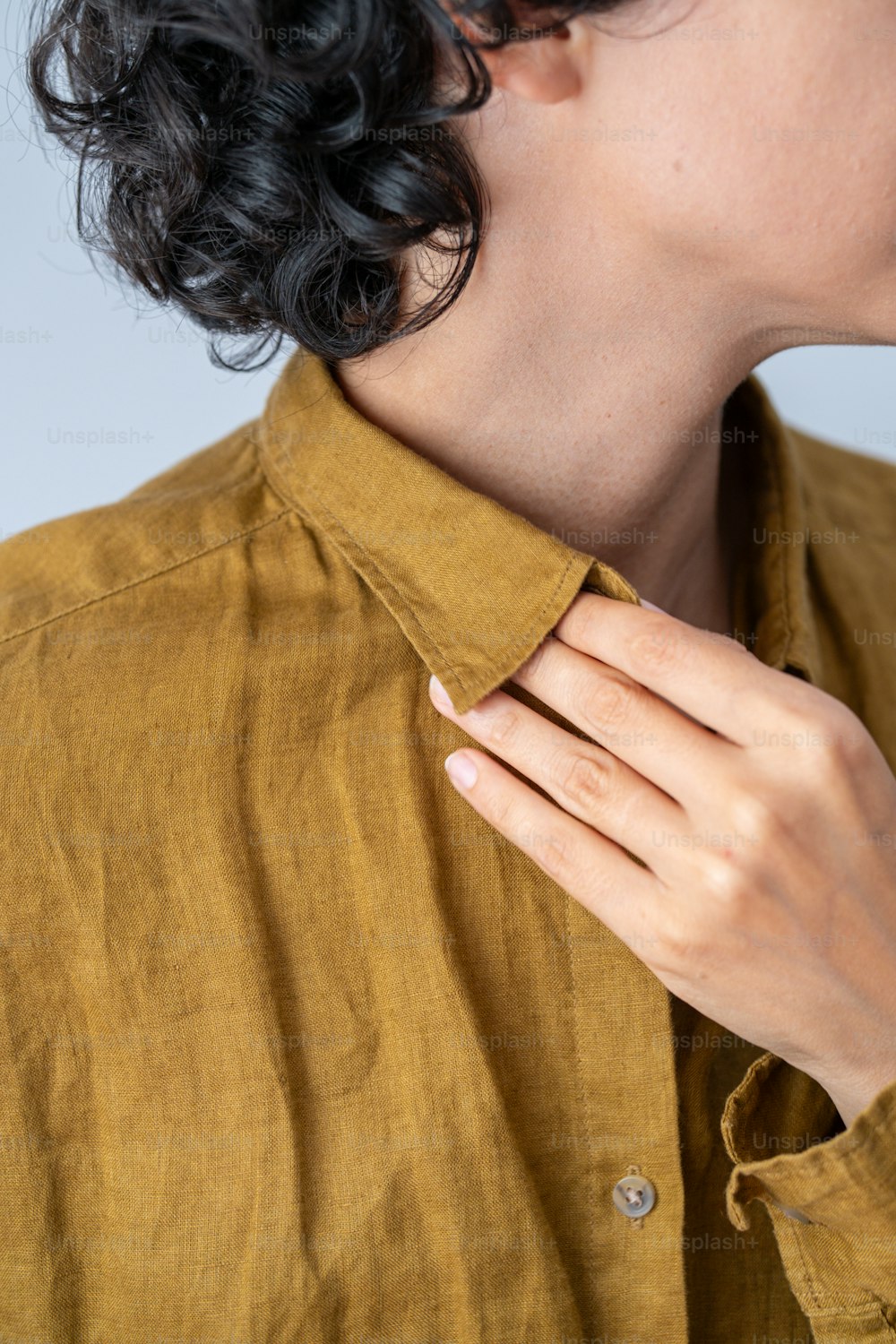 uma mulher vestindo uma camisa dourada e um anel de diamante