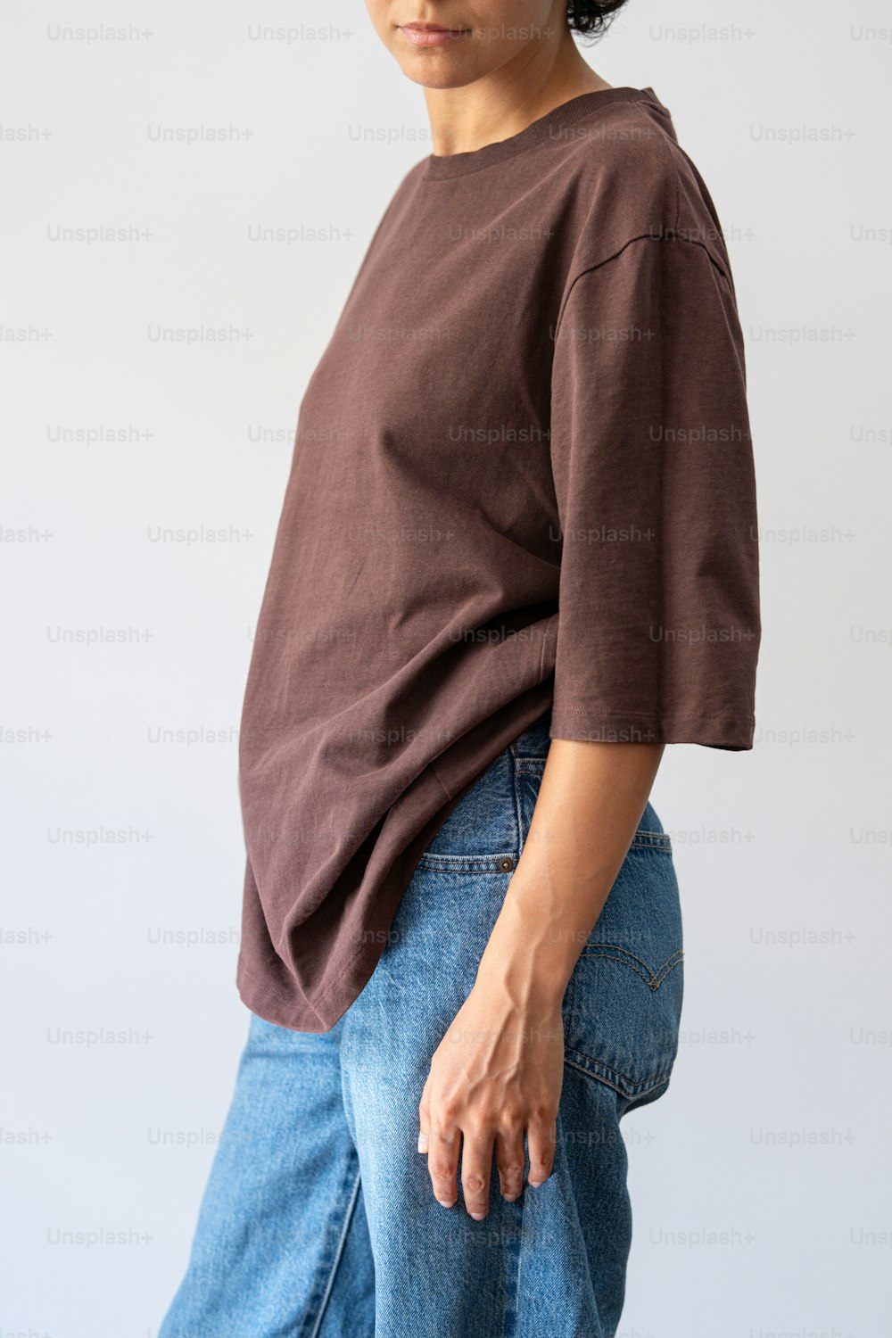 Una mujer con camisa marrón y jeans
