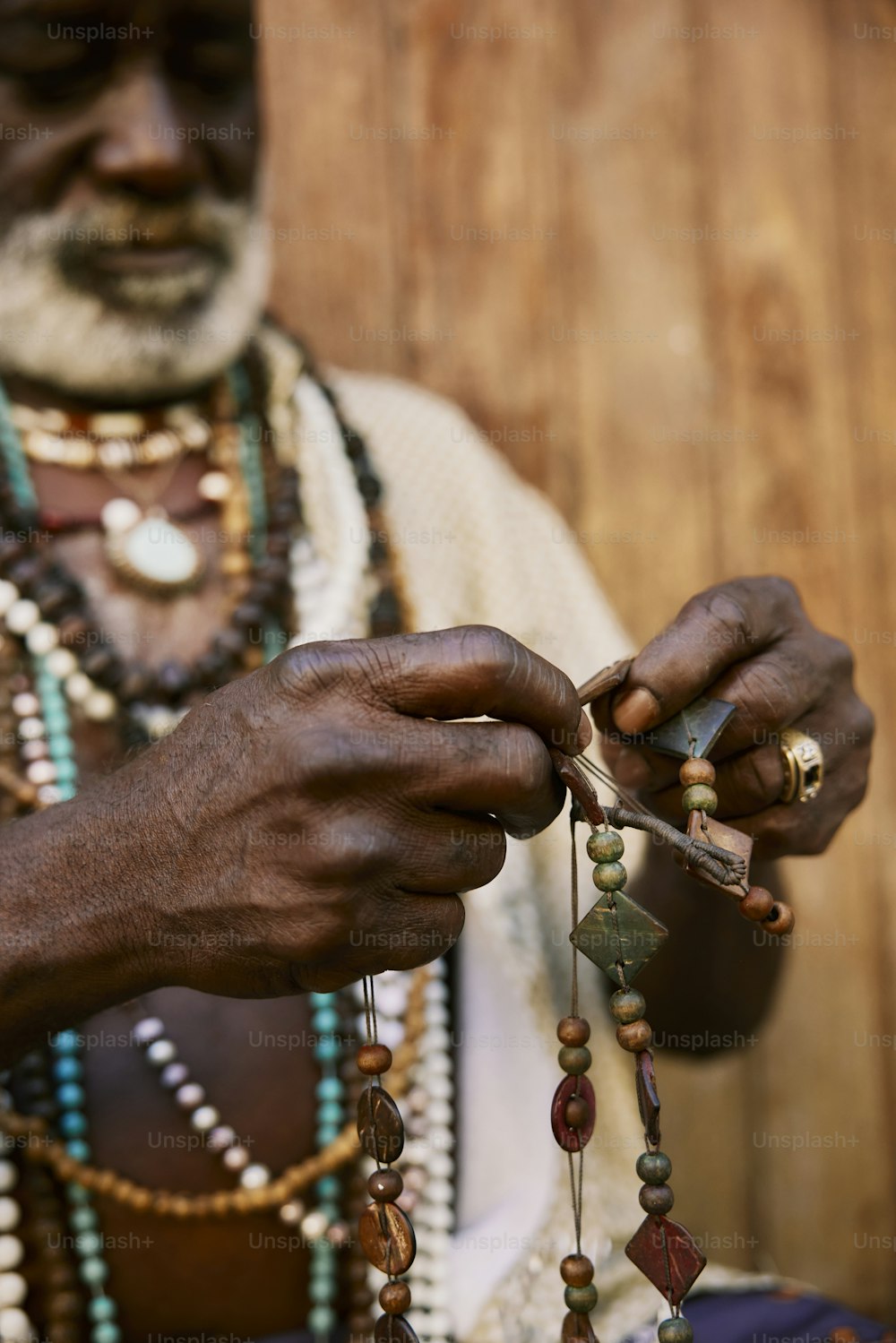 a man is holding beads and a pair of scissors