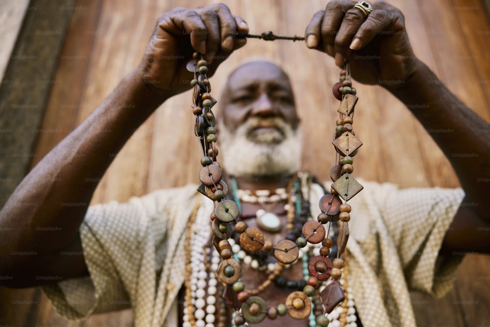 Ein Mann hält eine Halskette mit Perlen in der Hand