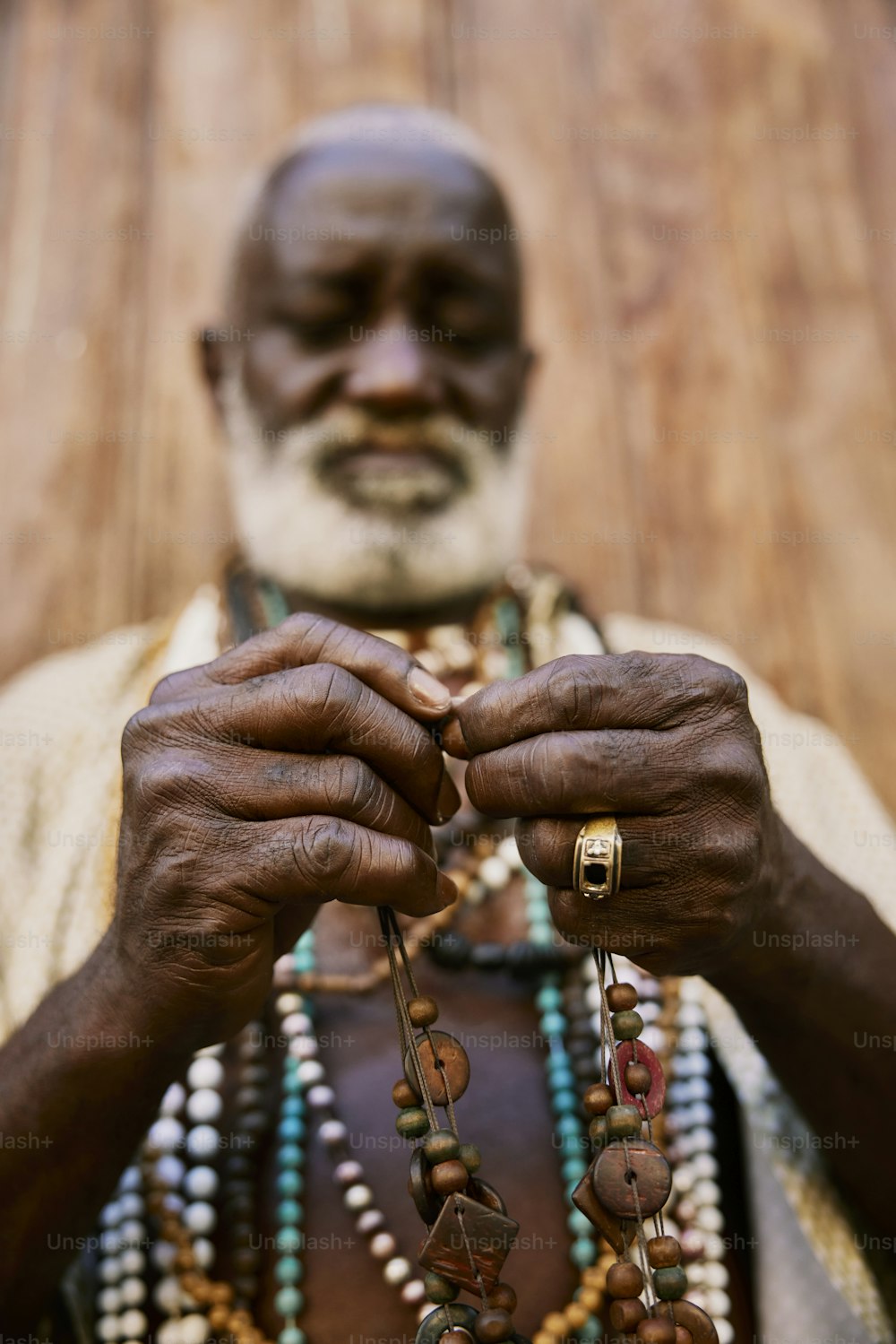 a man with a white beard holding a beaded necklace