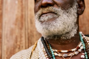a man with a white beard wearing a necklace