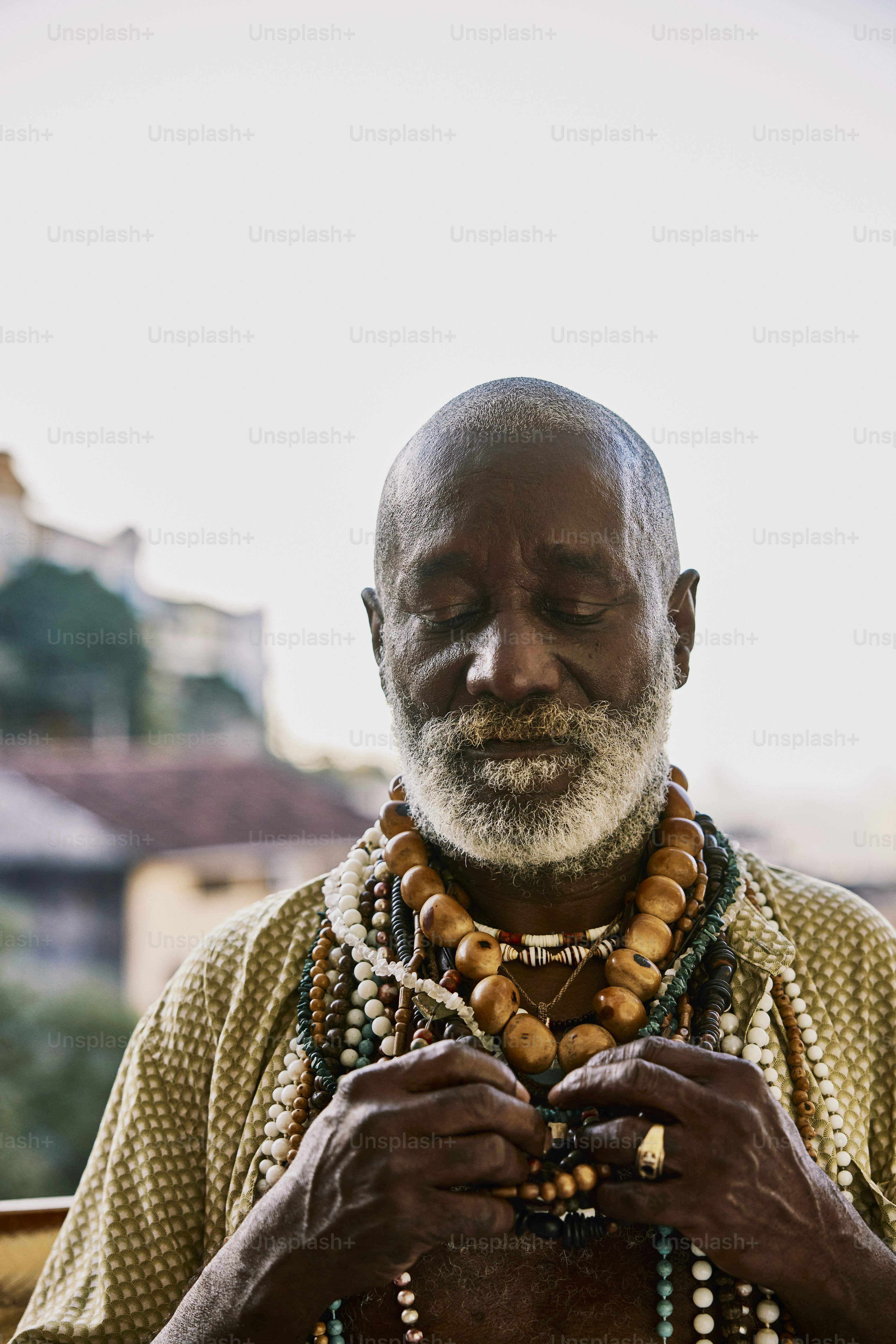 Un homme avec une barbe et des perles autour du cou