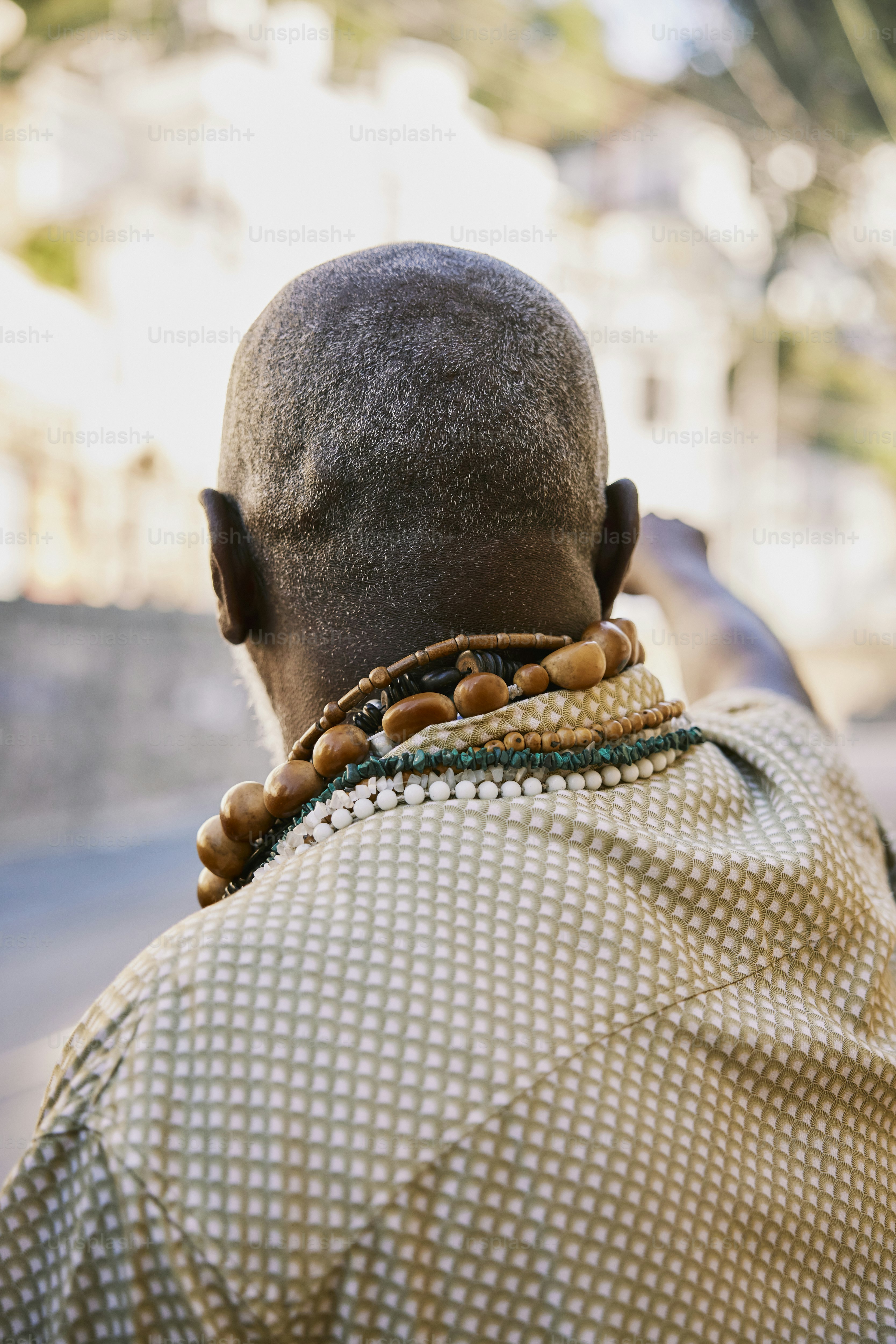 Um homem com um colar no pescoço foto – Imagem sobre Preto na Unsplash