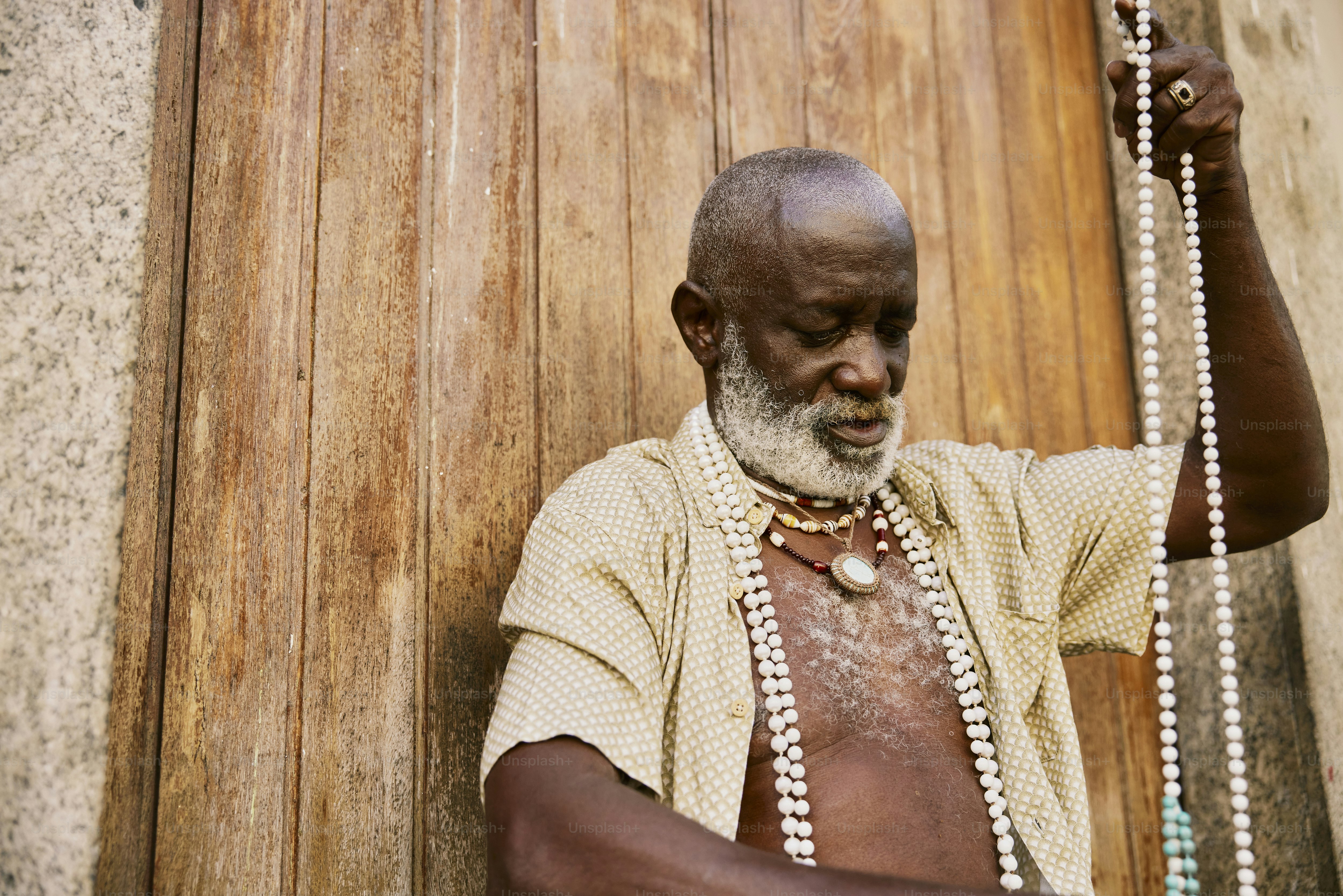 a man with a white beard wearing a beaded necklace
