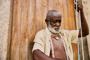 a man with a white beard wearing a beaded necklace