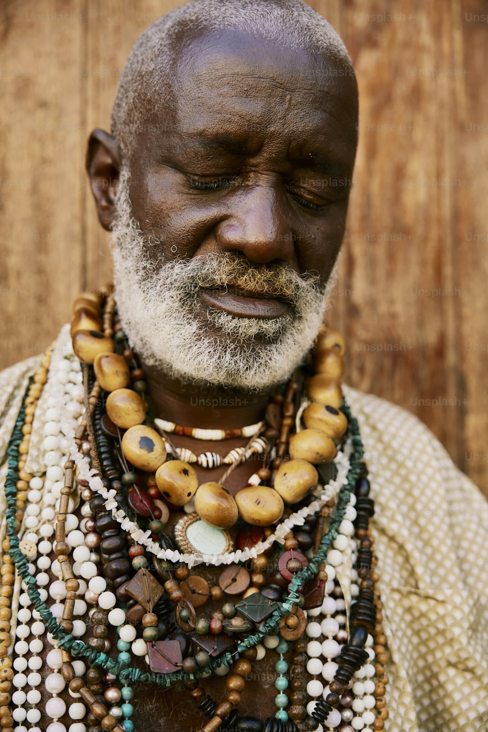 a man with a beard wearing a variety of necklaces