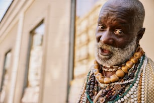 an old man with a beard and necklaces