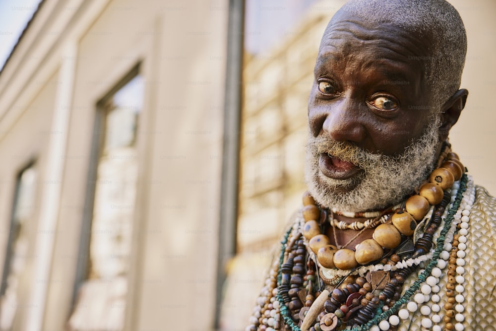 an old man with a beard and necklaces