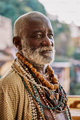 a man with a white beard wearing beads