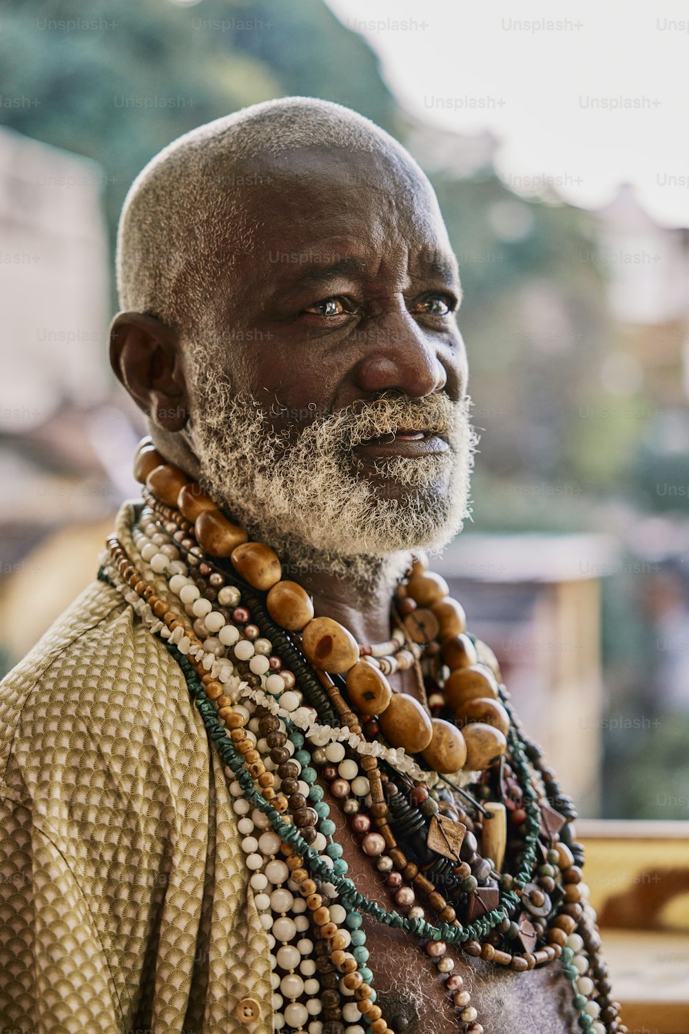 a man with a white beard wearing beads