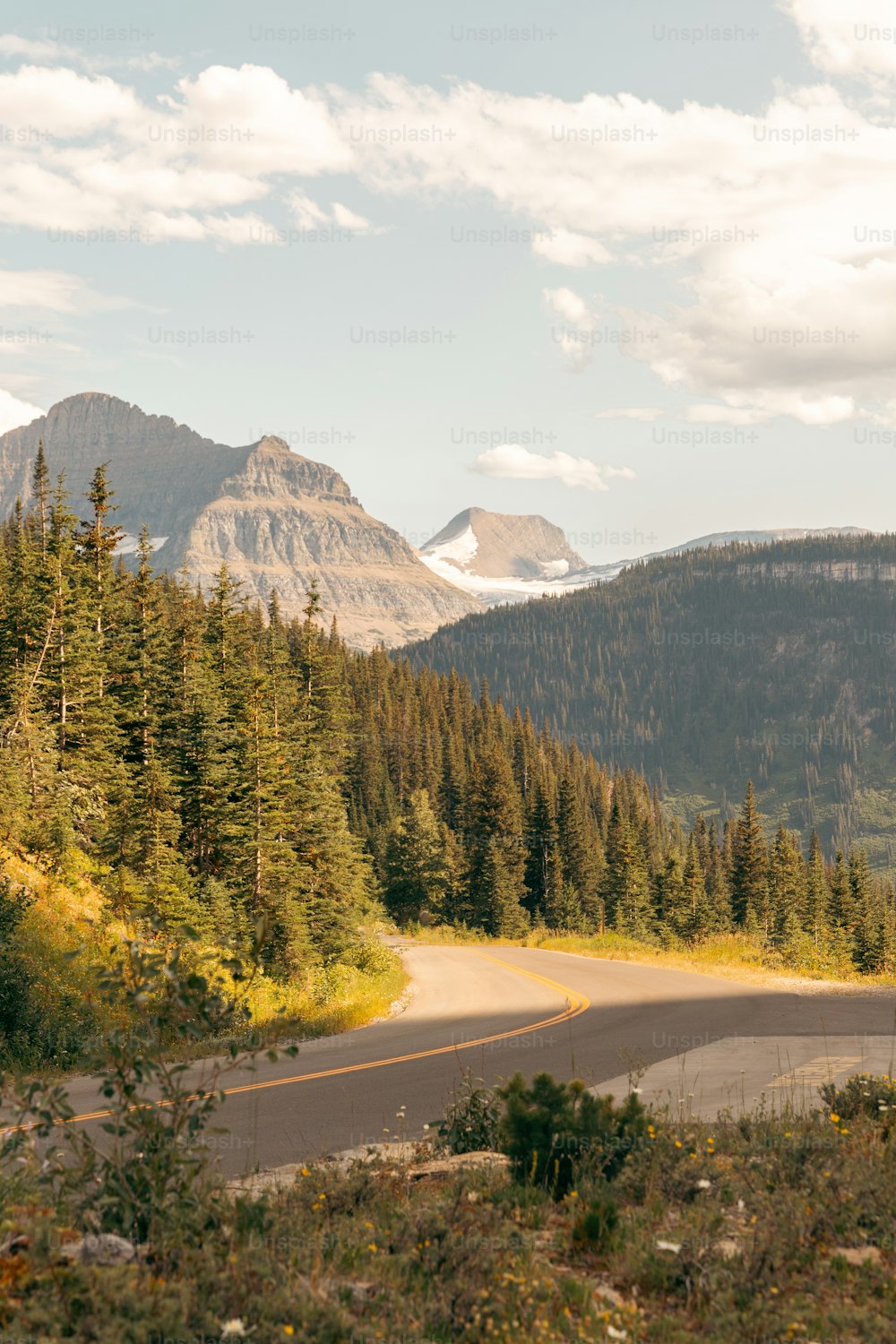 Una vista panorámica de una cadena montañosa con una carretera en primer plano