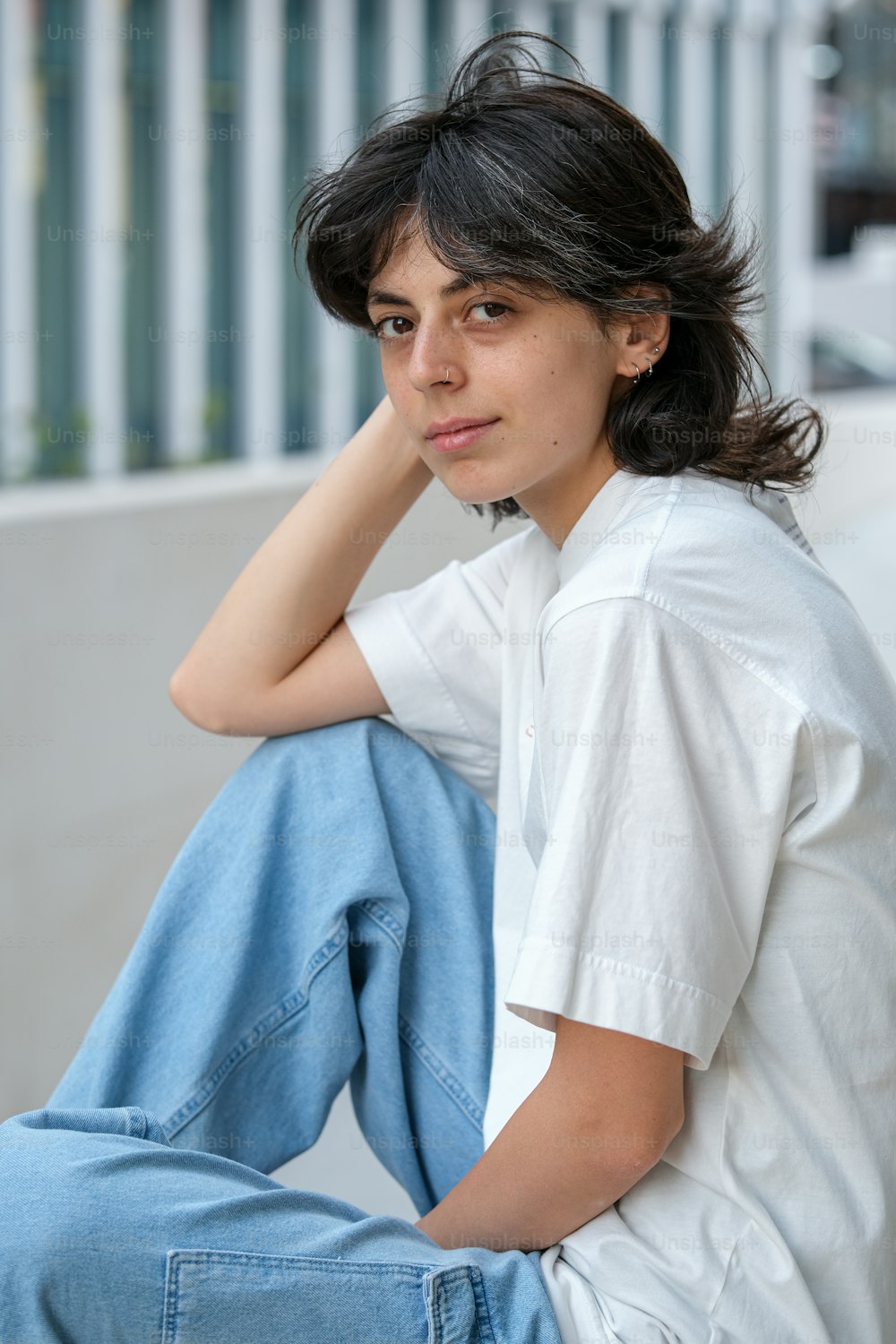 a woman sitting on the ground with her hand on her head