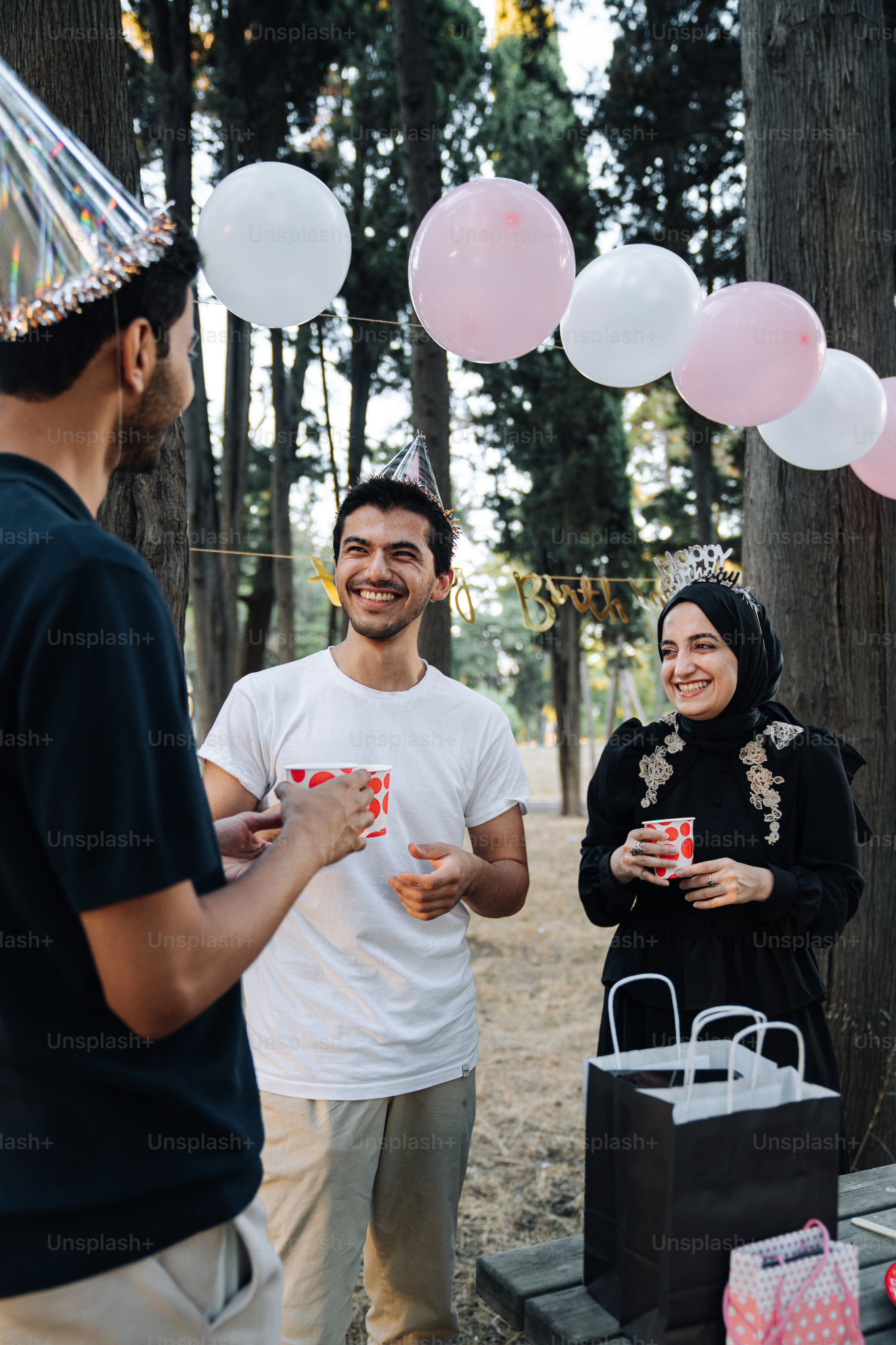 A group of people standing around a picnic table photo – Birthday party ...