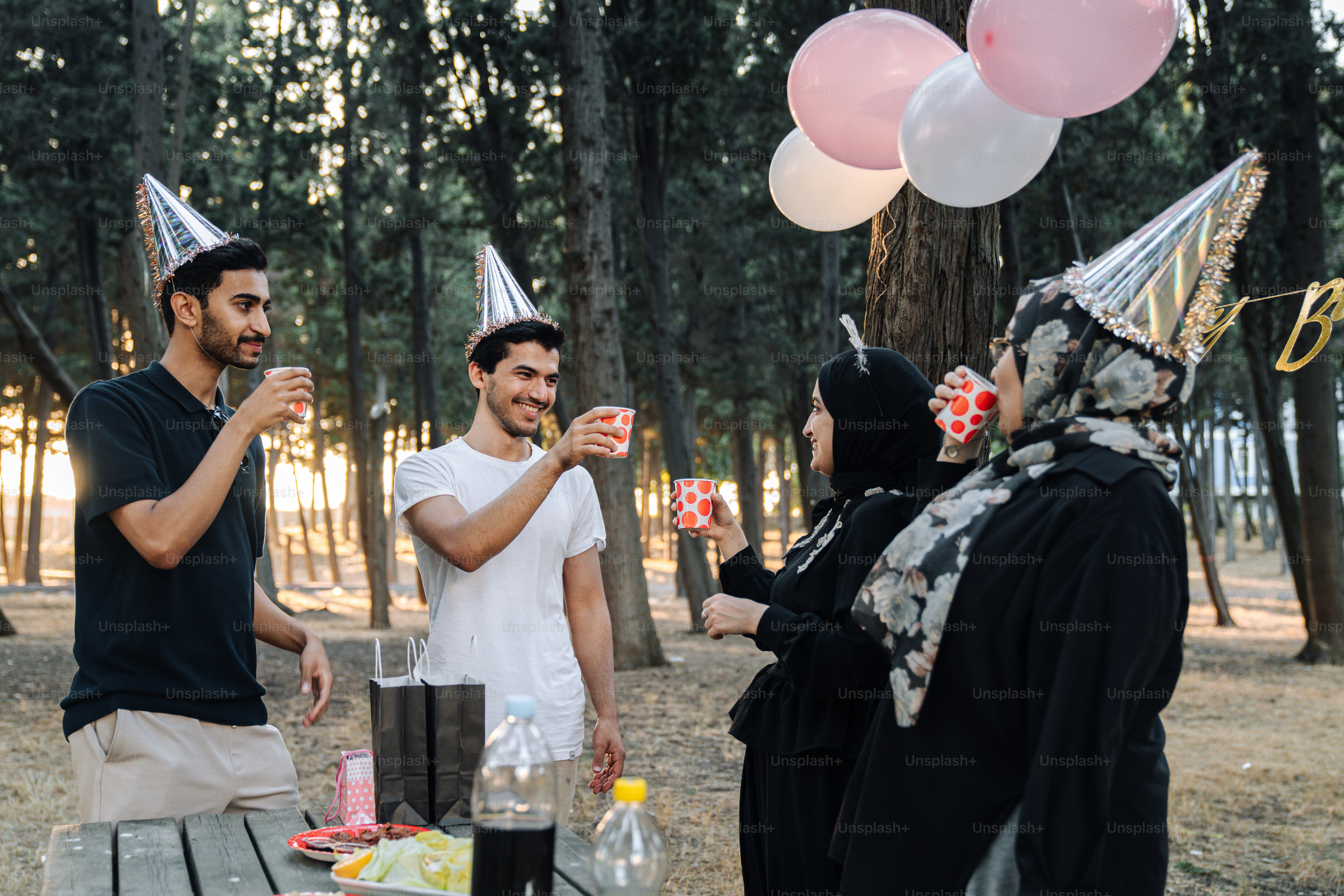 A group of people standing around a picnic table photo – Birthday party ...