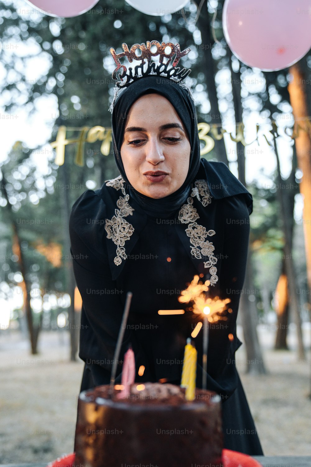 a woman blowing out candles on a cake